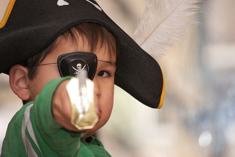 photograph of boy with sword, eye patch, and pirate hat with feather