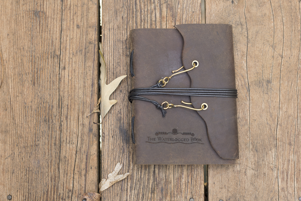 photo of a leather-bound journal on a wood background